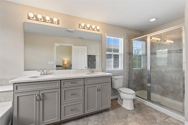 bathroom with tile patterned floors, walk in shower, vanity, and toilet