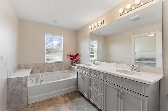 bathroom with a textured ceiling, tile patterned flooring, vanity, and a washtub