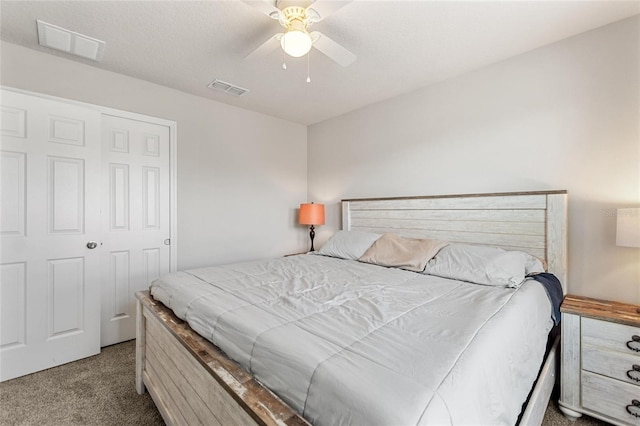 bedroom featuring ceiling fan, a textured ceiling, a closet, and light carpet