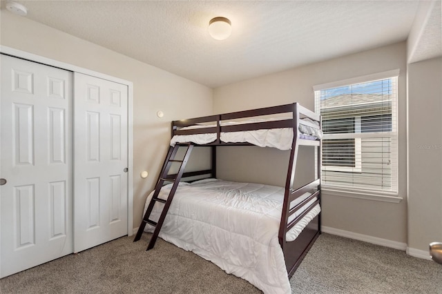 bedroom with a textured ceiling, a closet, and carpet