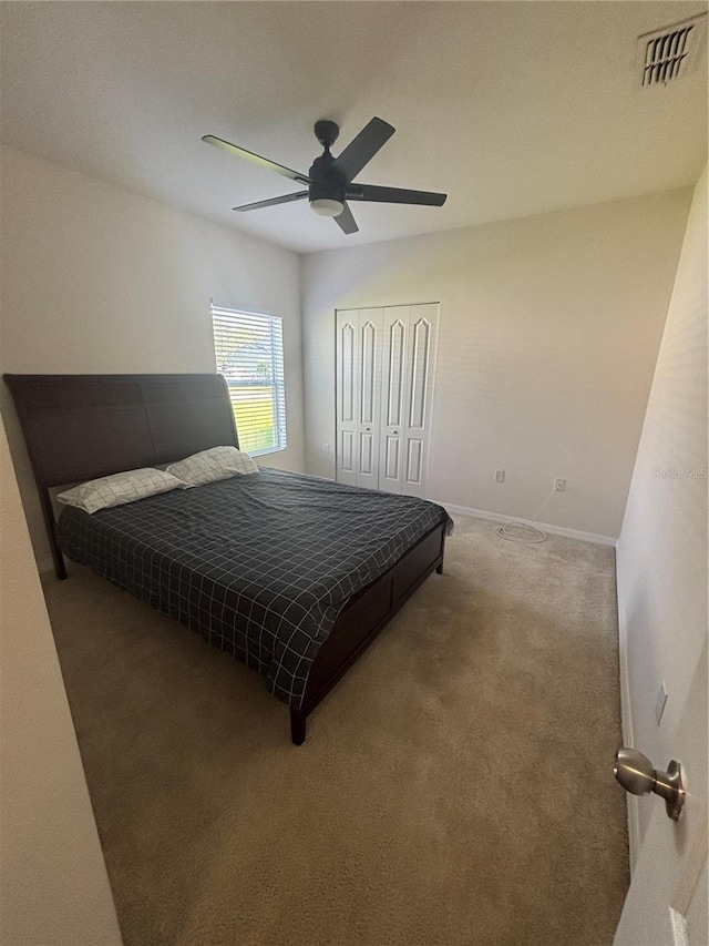 carpeted bedroom featuring a closet and ceiling fan