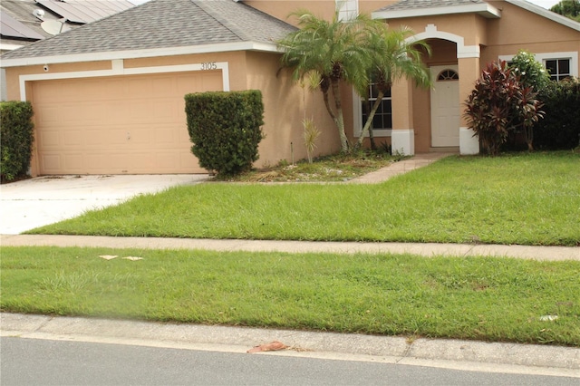 view of front of property with a garage and a front yard