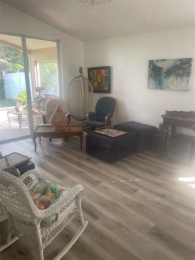 sitting room with hardwood / wood-style flooring and a chandelier