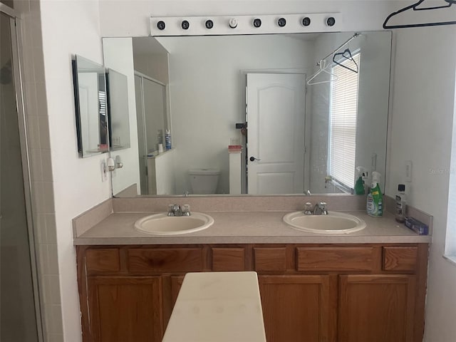 bathroom featuring vanity, toilet, and an enclosed shower