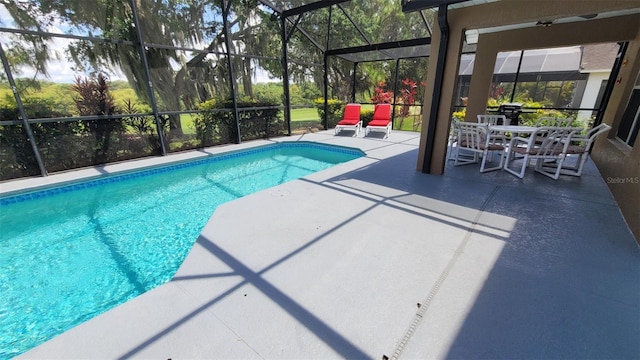 view of swimming pool featuring a patio area and glass enclosure