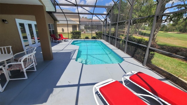 view of swimming pool featuring a yard, a patio, and a lanai