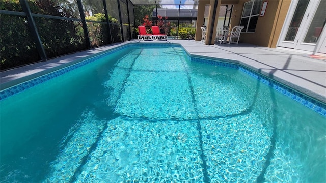 view of swimming pool featuring a patio and a lanai