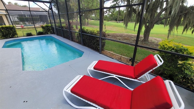 view of pool with a patio, a lawn, and a lanai