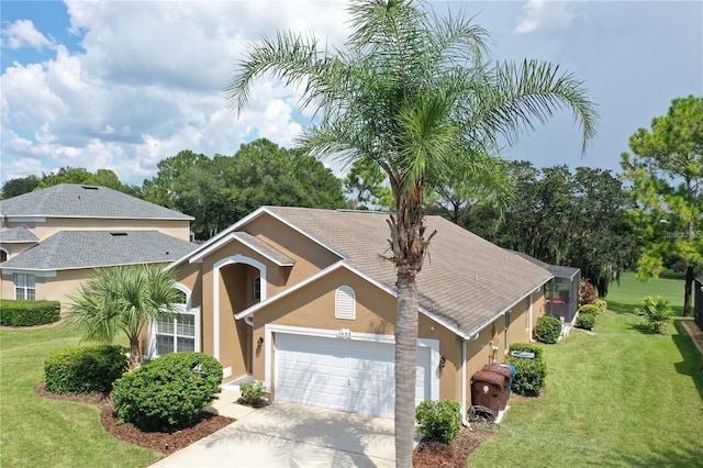 view of front of home with an attached garage, driveway, a front lawn, and stucco siding