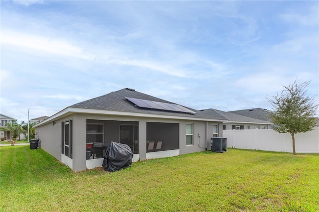 872 Sydney St, Davenport, FL 33837 - back of house featuring roof mounted solar panels, roof with shingles, a sunroom, central AC unit, and stucco siding