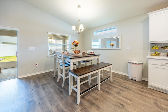 872 Sydney St, Davenport, FL 33837 - dining room with light wood finished floors, a chandelier, vaulted ceiling, and baseboards