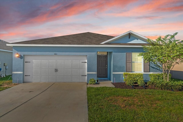 view of front of property with a garage and a yard