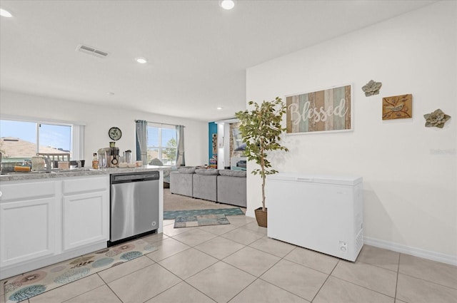 kitchen featuring white cabinetry, dishwasher, light tile patterned floors, and sink