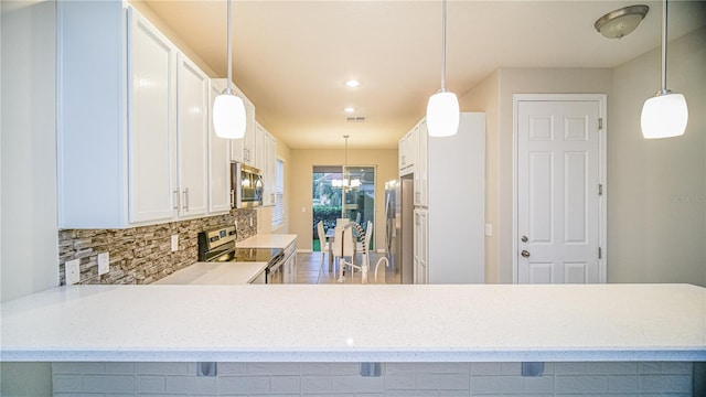 kitchen featuring appliances with stainless steel finishes, kitchen peninsula, and white cabinets