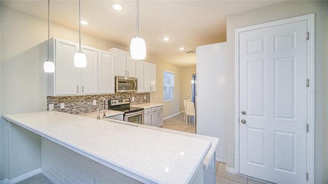 kitchen with pendant lighting, light tile patterned flooring, kitchen peninsula, white cabinetry, and appliances with stainless steel finishes