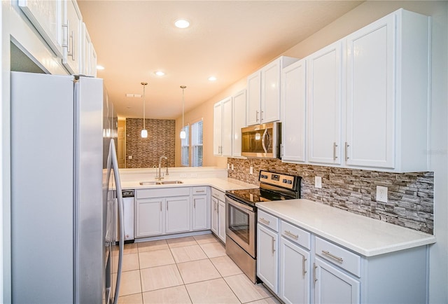 kitchen with white cabinets, appliances with stainless steel finishes, hanging light fixtures, and sink