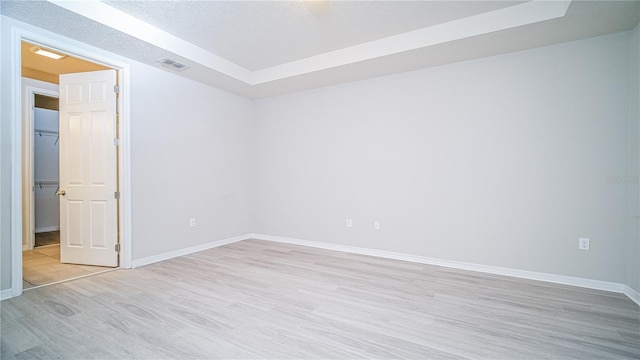 spare room featuring light hardwood / wood-style flooring and a textured ceiling