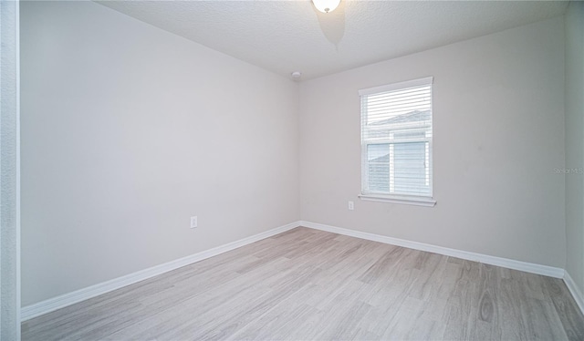 unfurnished room with light hardwood / wood-style floors and a textured ceiling