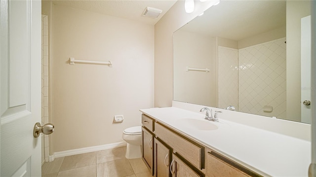 bathroom with tiled shower, vanity, a textured ceiling, toilet, and tile patterned floors