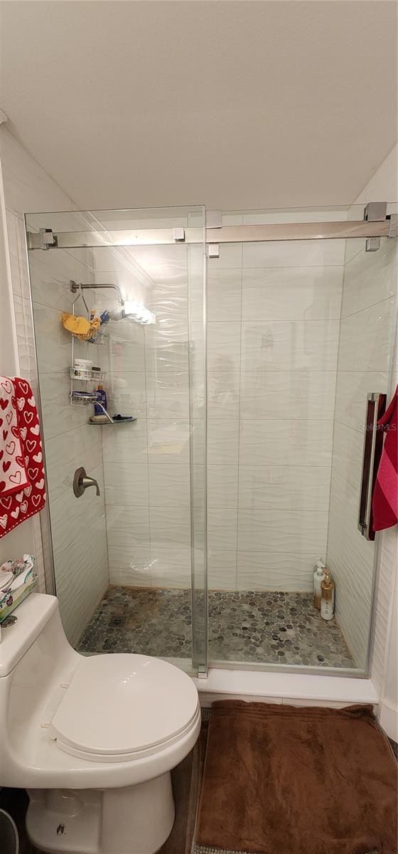 bathroom with toilet and an enclosed shower