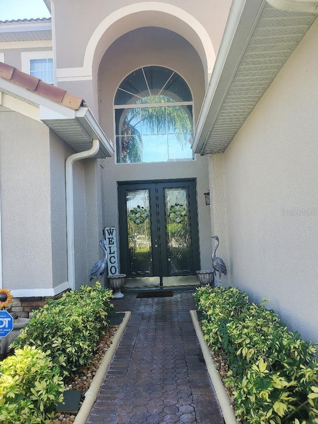 view of exterior entry featuring stucco siding and french doors