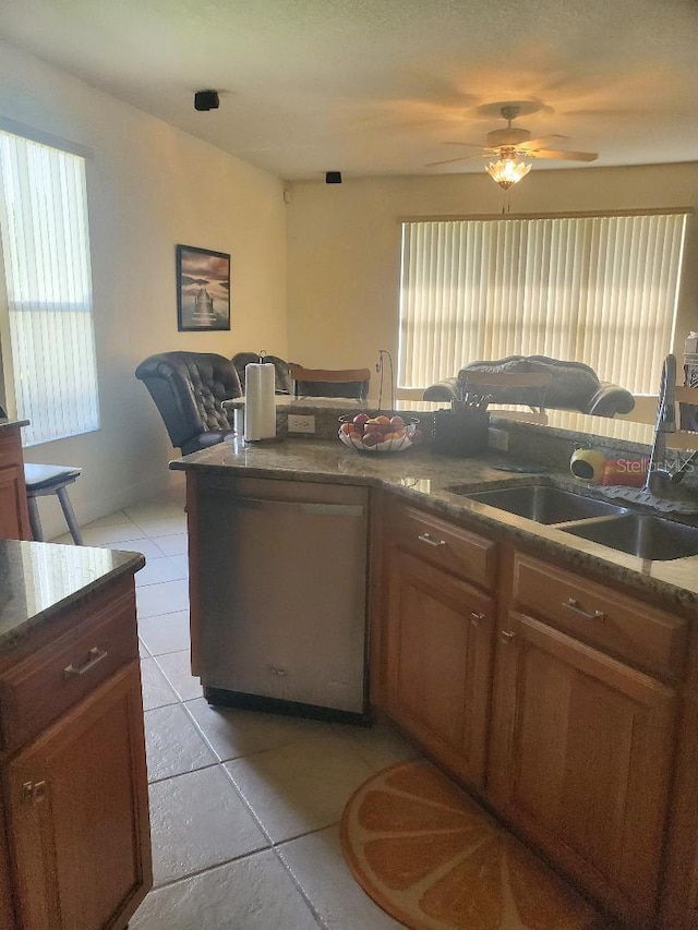 kitchen with stainless steel dishwasher, sink, light tile patterned floors, and ceiling fan