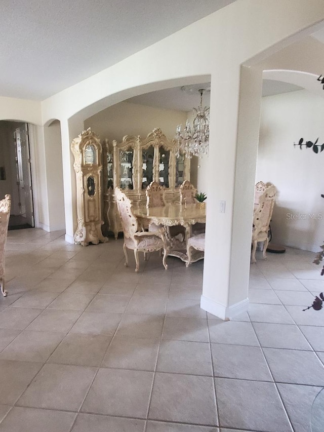 dining room with a notable chandelier, a textured ceiling, and tile patterned floors