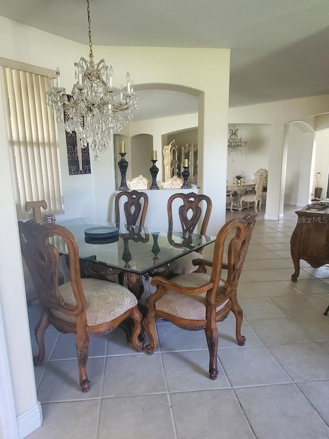 dining area featuring tile patterned floors and a chandelier