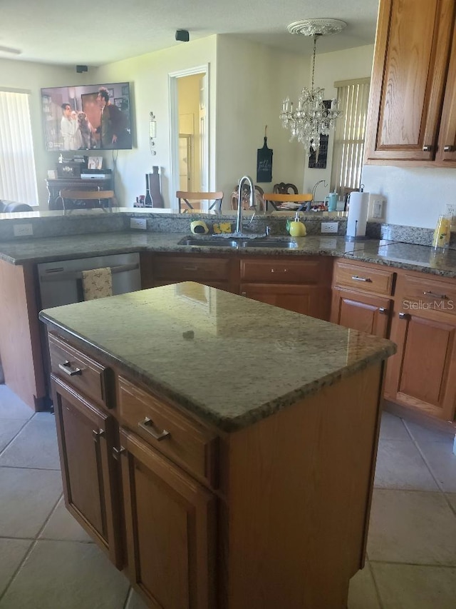 kitchen with sink, a center island, a notable chandelier, and light tile patterned floors