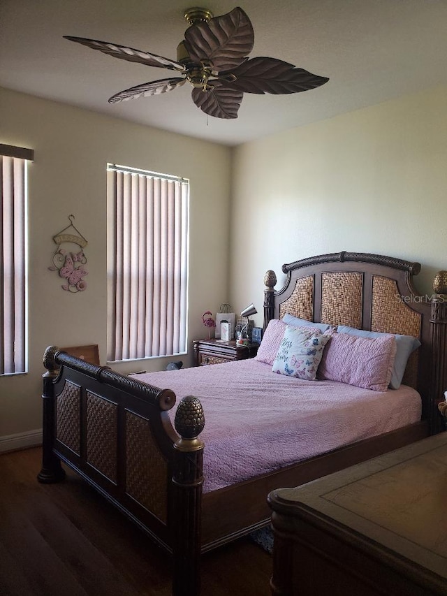 bedroom with dark wood-type flooring, ceiling fan, and multiple windows