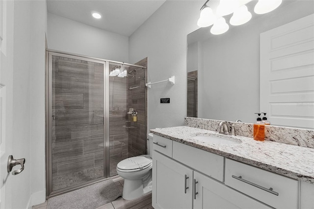 bathroom with an enclosed shower, vanity, and toilet