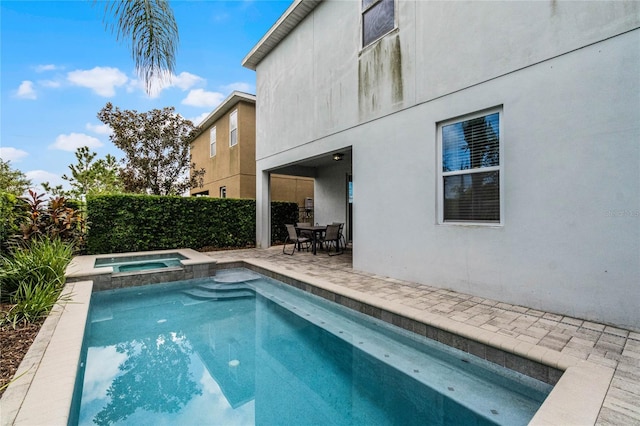 view of pool with a patio and an in ground hot tub