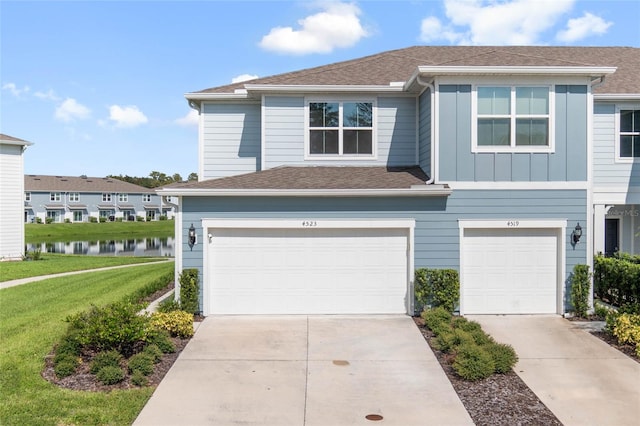 view of front of property featuring a water view, a garage, and a front yard