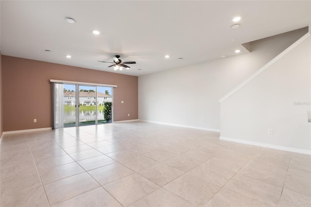 tiled spare room with ceiling fan