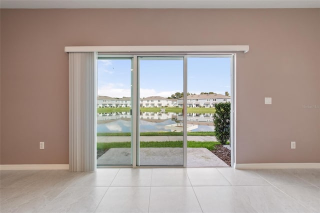 doorway to outside featuring light tile patterned floors and a water view