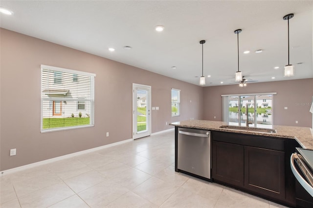 kitchen with appliances with stainless steel finishes, a healthy amount of sunlight, light stone counters, and hanging light fixtures