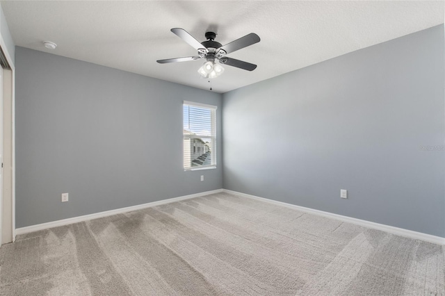 carpeted empty room featuring ceiling fan