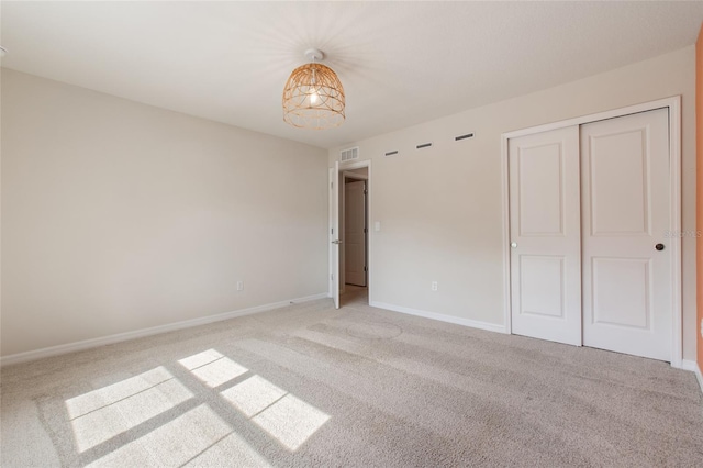 unfurnished bedroom with light carpet and a closet