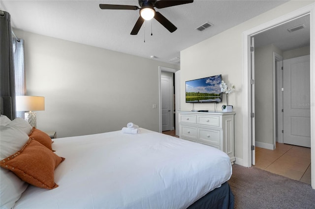 bedroom featuring ceiling fan, a textured ceiling, and tile patterned floors