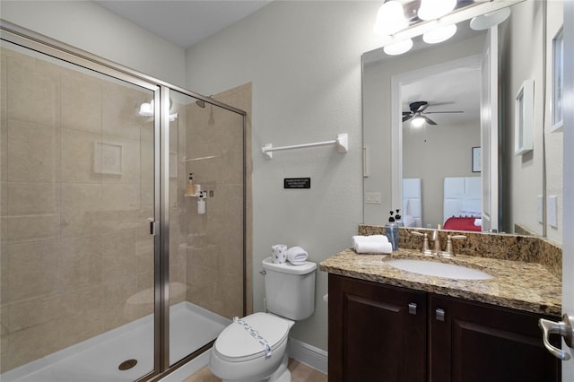 bathroom featuring vanity, a shower with shower door, and toilet