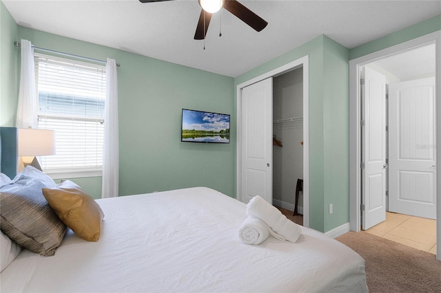 bedroom featuring ceiling fan, a closet, and light tile patterned floors