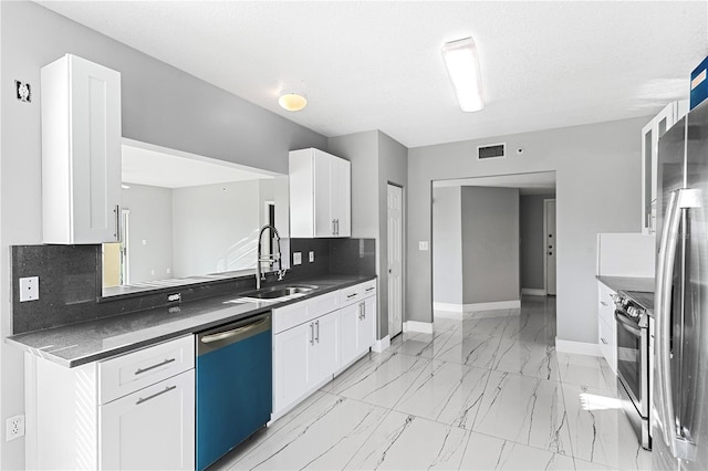 kitchen featuring appliances with stainless steel finishes, backsplash, white cabinetry, and sink