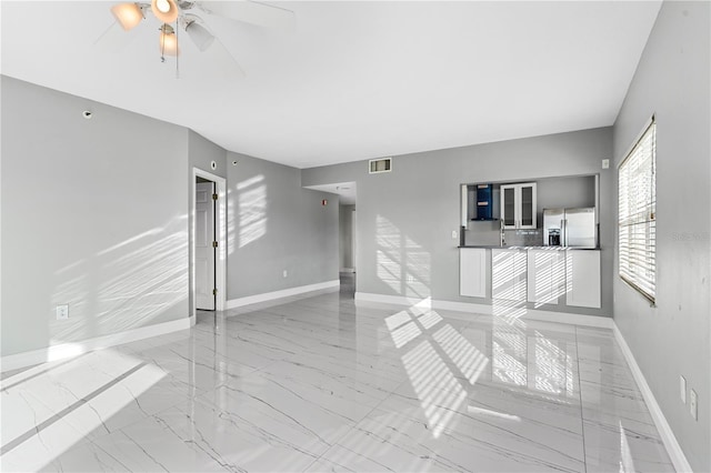 unfurnished living room with ceiling fan