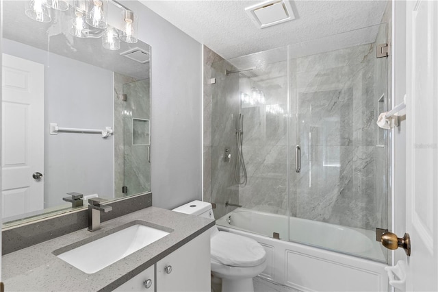 full bathroom with a textured ceiling, shower / bath combination with glass door, vanity, and toilet