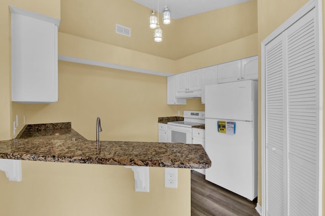 kitchen with white cabinets, kitchen peninsula, white appliances, decorative light fixtures, and dark hardwood / wood-style floors