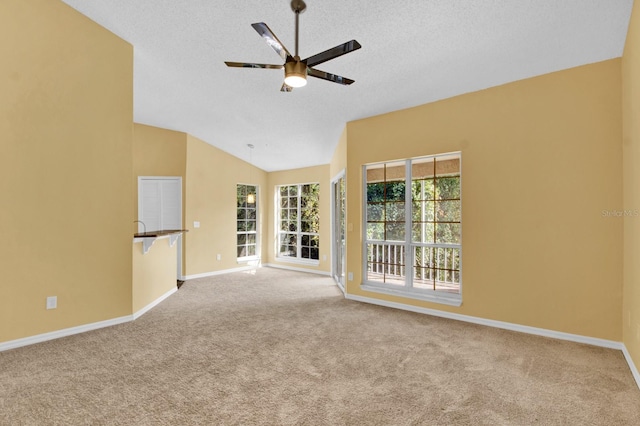 unfurnished room with ceiling fan, light colored carpet, a textured ceiling, and lofted ceiling