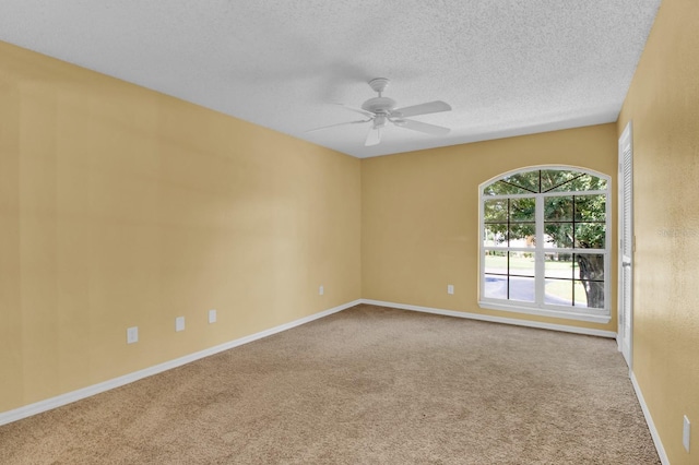 carpeted spare room with a textured ceiling and ceiling fan