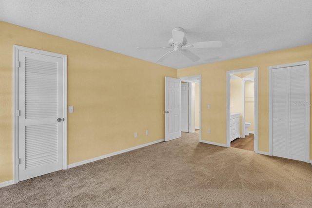 unfurnished bedroom featuring ceiling fan, light colored carpet, ensuite bathroom, and a textured ceiling