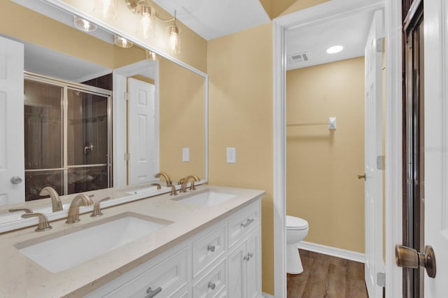 bathroom featuring vanity, a shower with shower door, toilet, and hardwood / wood-style flooring