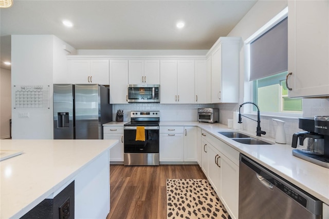 kitchen featuring stainless steel appliances, dark wood-type flooring, sink, and white cabinetry